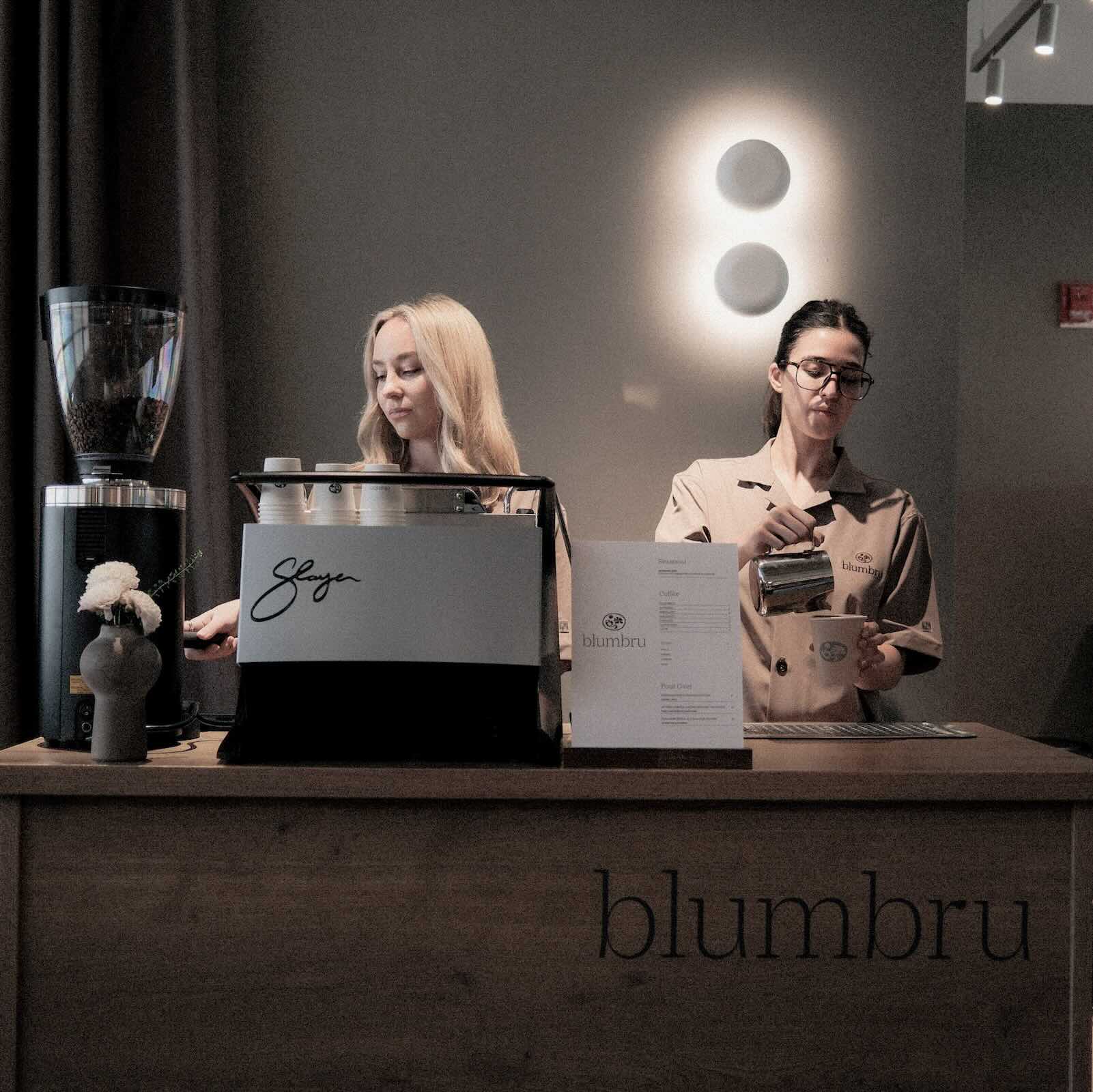 2 baristas working behind mobile coffee catering bar.