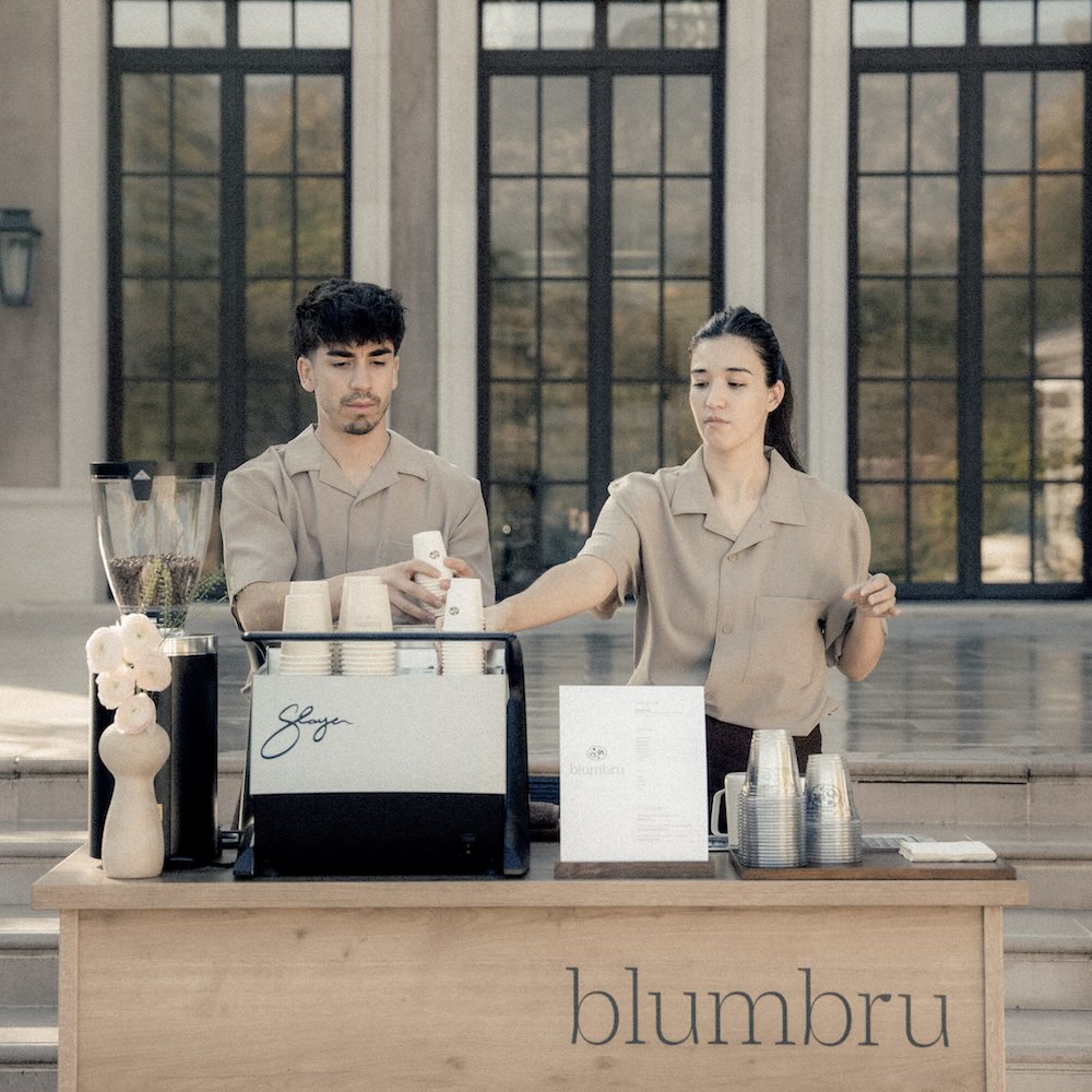 2 baristas working behind coffee catering bar.