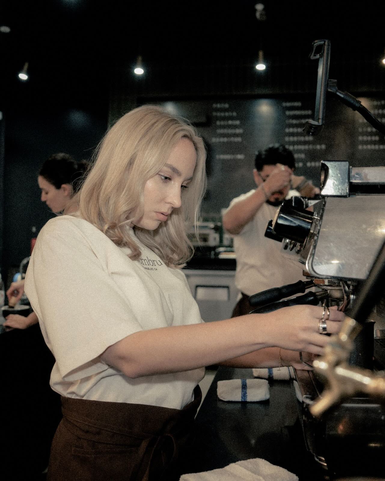 Barista working on a coffee machine.