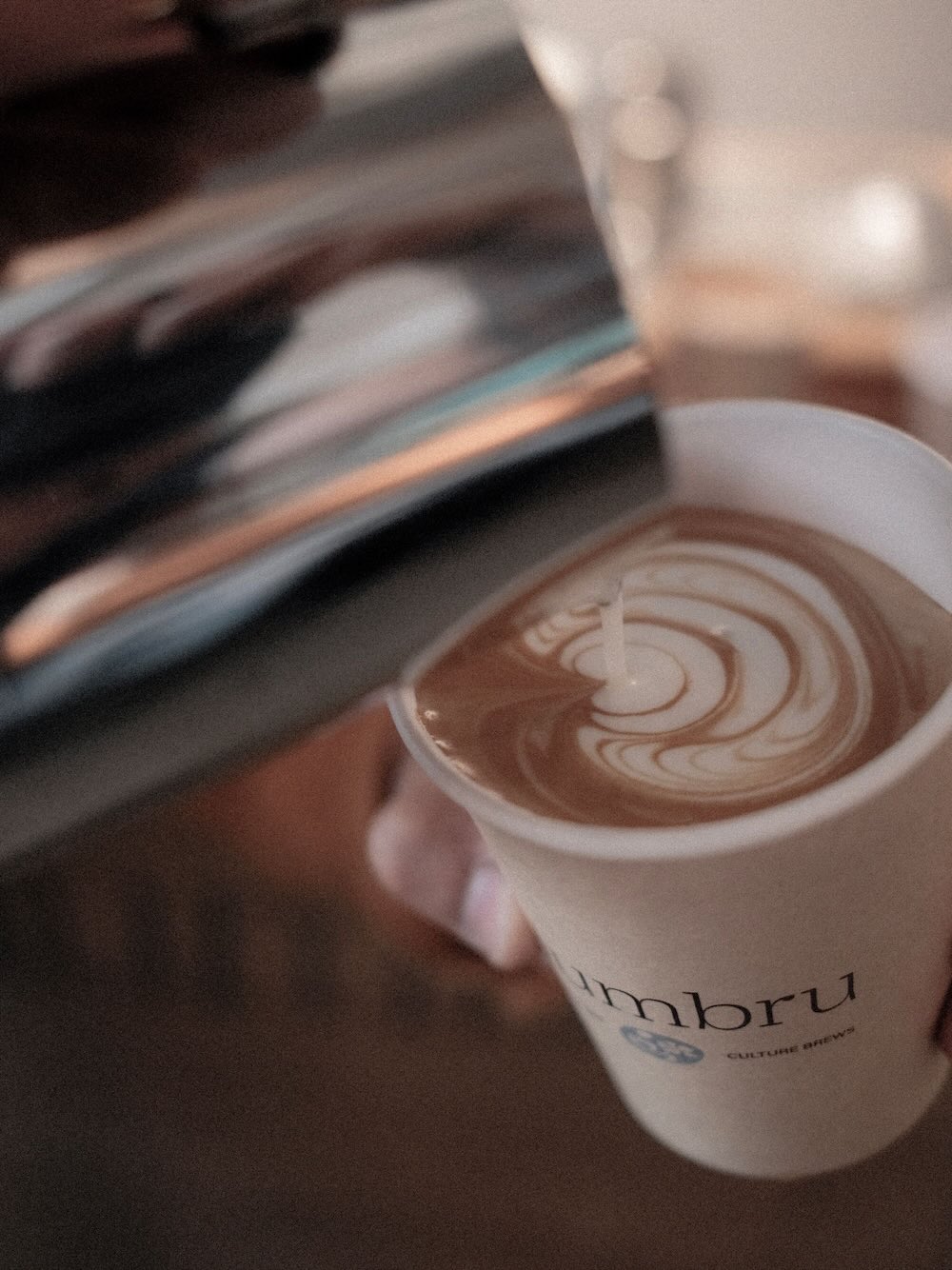 Milk being poured into coffee adding a stylized shape.