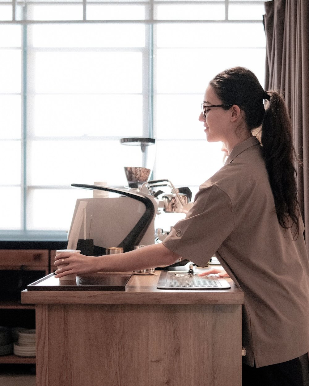 Barista serving coffee behind mobile coffee bar.