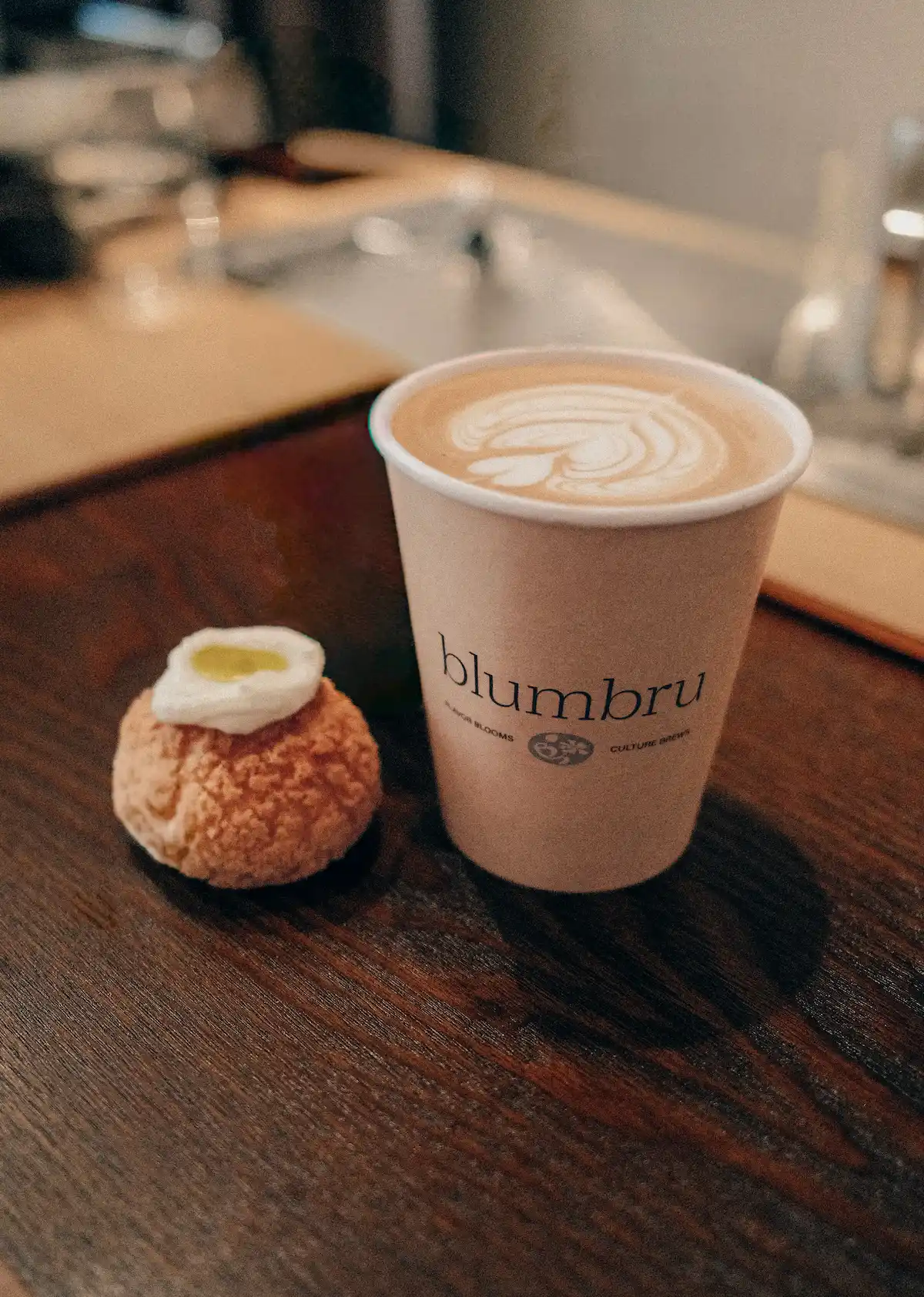 latte with latte art in blumbru branded cup coffee catering service