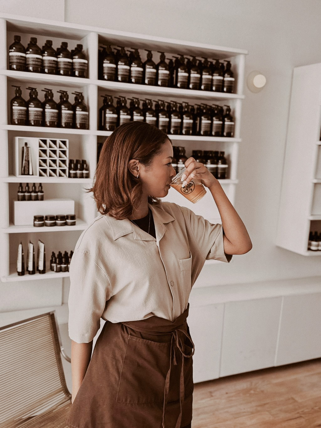 Guest sipping an iced coffee inside Aesop Venice