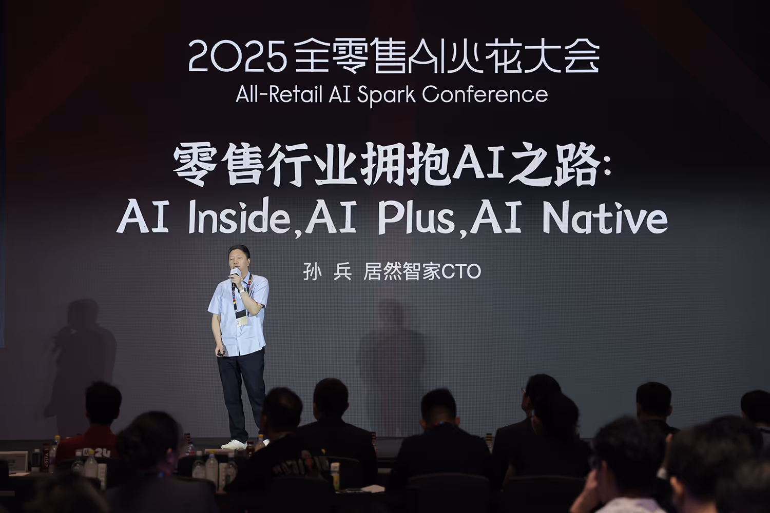 Speaker presenting at the 2025 All-Retail AI Spark Conference with a slide titled 'AI Inside, AI Plus, AI Native' in both Chinese and English.