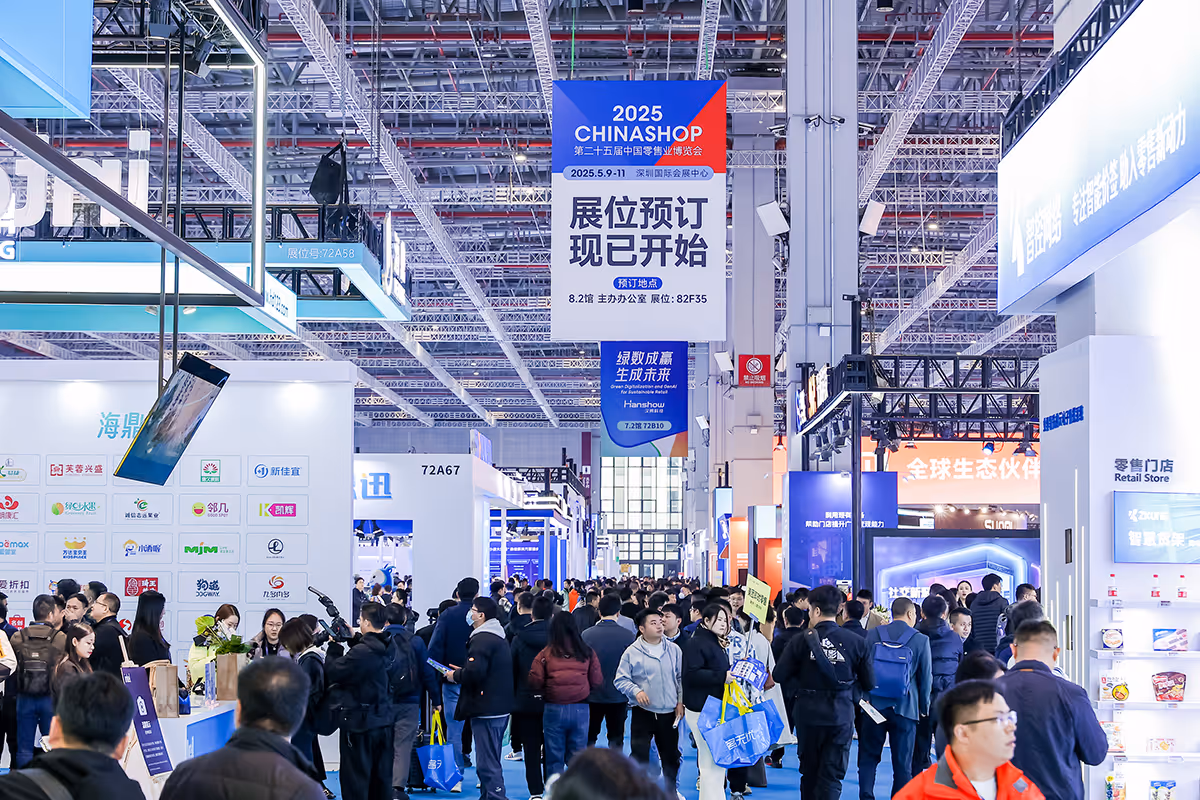 Crowded exhibition hall with attendees walking and browsing booths at a trade show featuring a 2025 CHINASHOP banner.