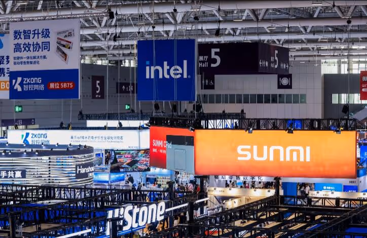 Exhibition hall with hanging signs for Intel, Sunmi, Zkong, and Stone at a technology trade show.