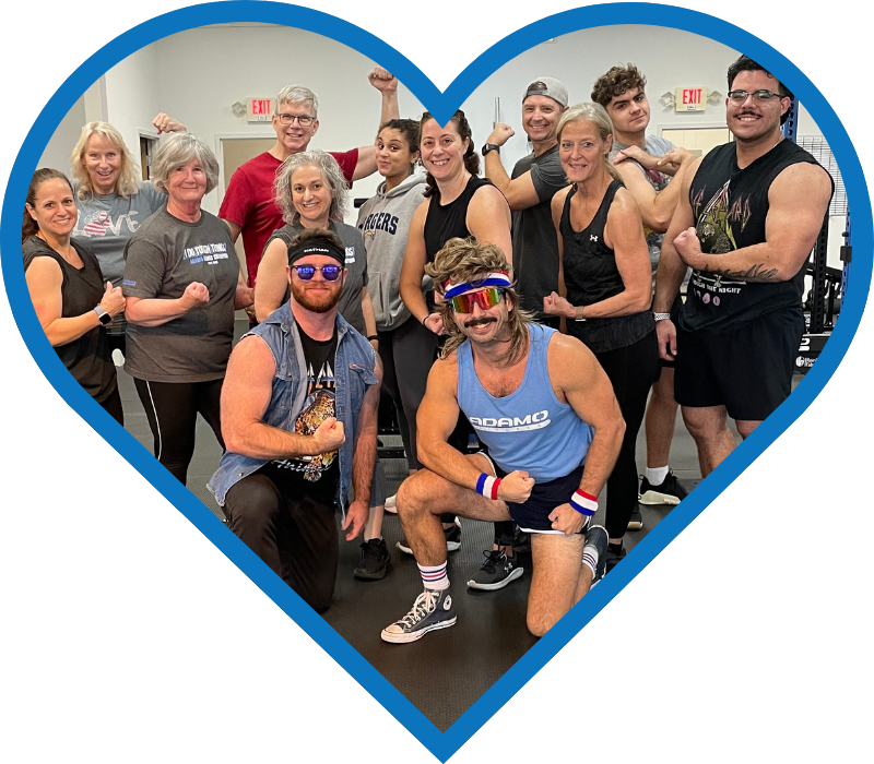 Group of diverse people in a gym flexing muscles and smiling, framed inside a blue heart shape.
