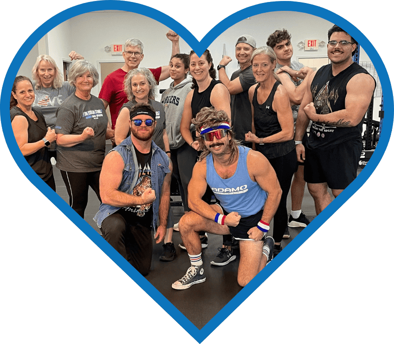 Group of diverse people in a gym flexing muscles and smiling, framed inside a blue heart shape.
