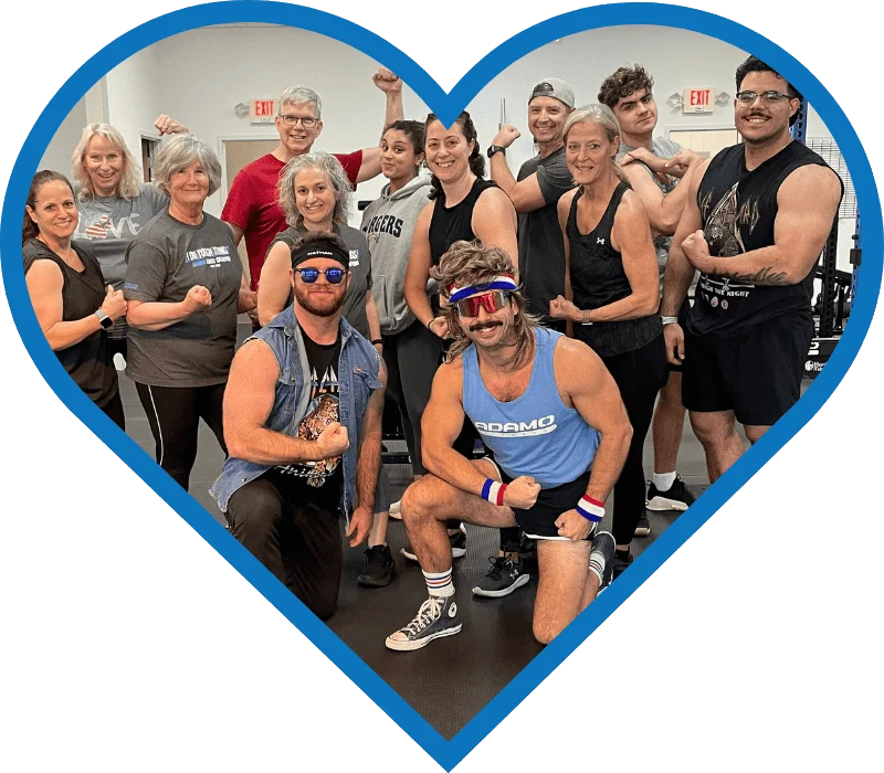 Group of diverse people in a gym flexing muscles and smiling, framed inside a blue heart shape.