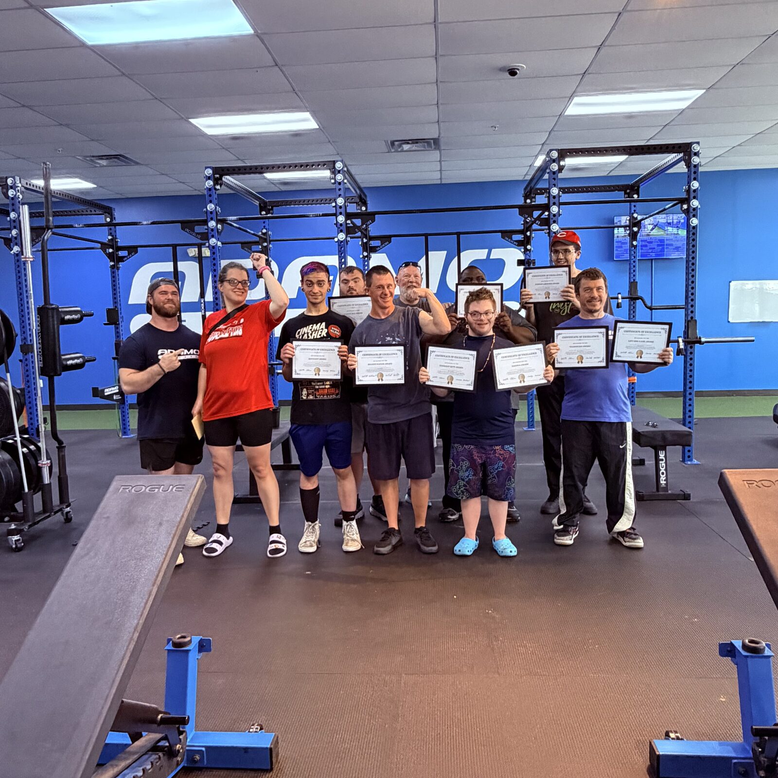 Athletes and coaches with certificates at an awards night at Adamo Fitness