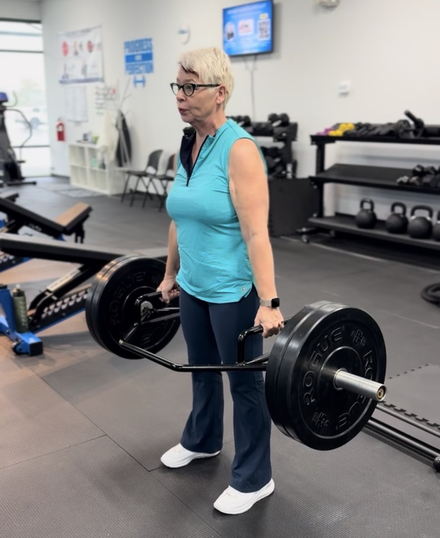 Nico, an Adamo member, deadlifting with a trap bar at the gym