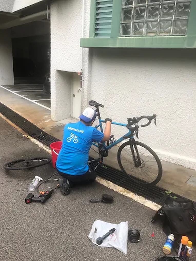 Bike Hero mechanic servicing a road bike at the kerbside
