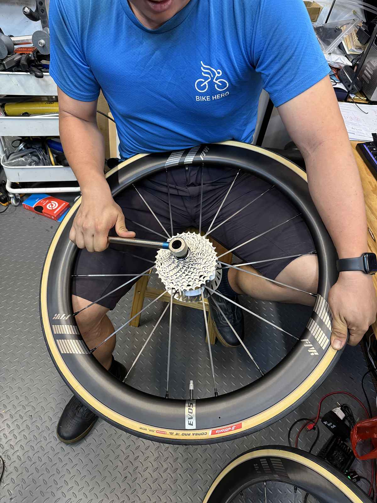 Bike Hero mechanic removing a cassette from a carbon wheel at the workshop