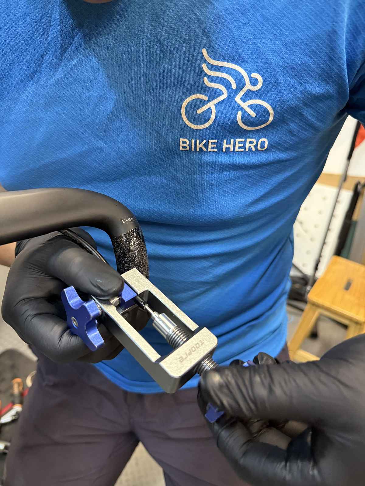 Bike Hero mechanic preparing a hydraulic brake hose with a cutting and barb tool