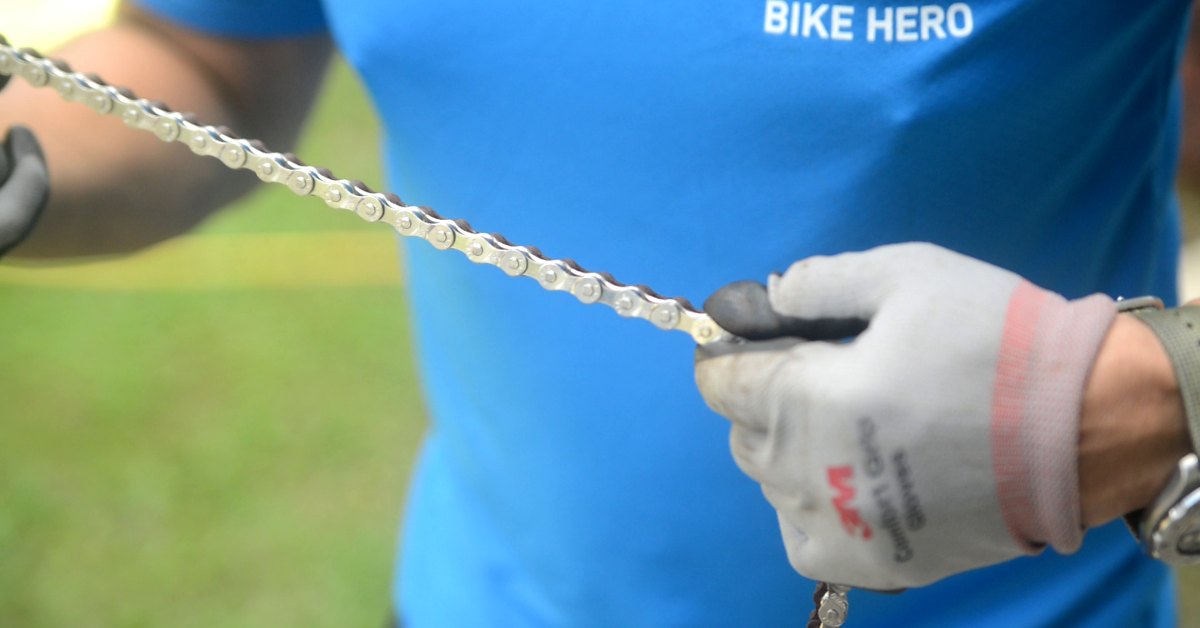 Bike Hero mechanic holding a new bicycle chain before fitting it at the doorstep