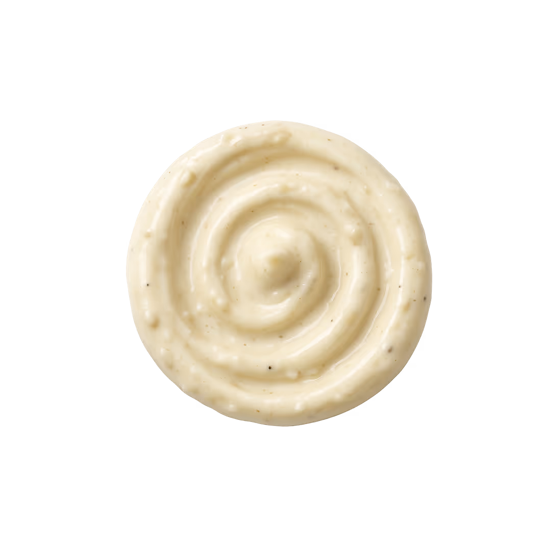 Swirl of creamy white garlic sauce with black pepper specks on a white background.