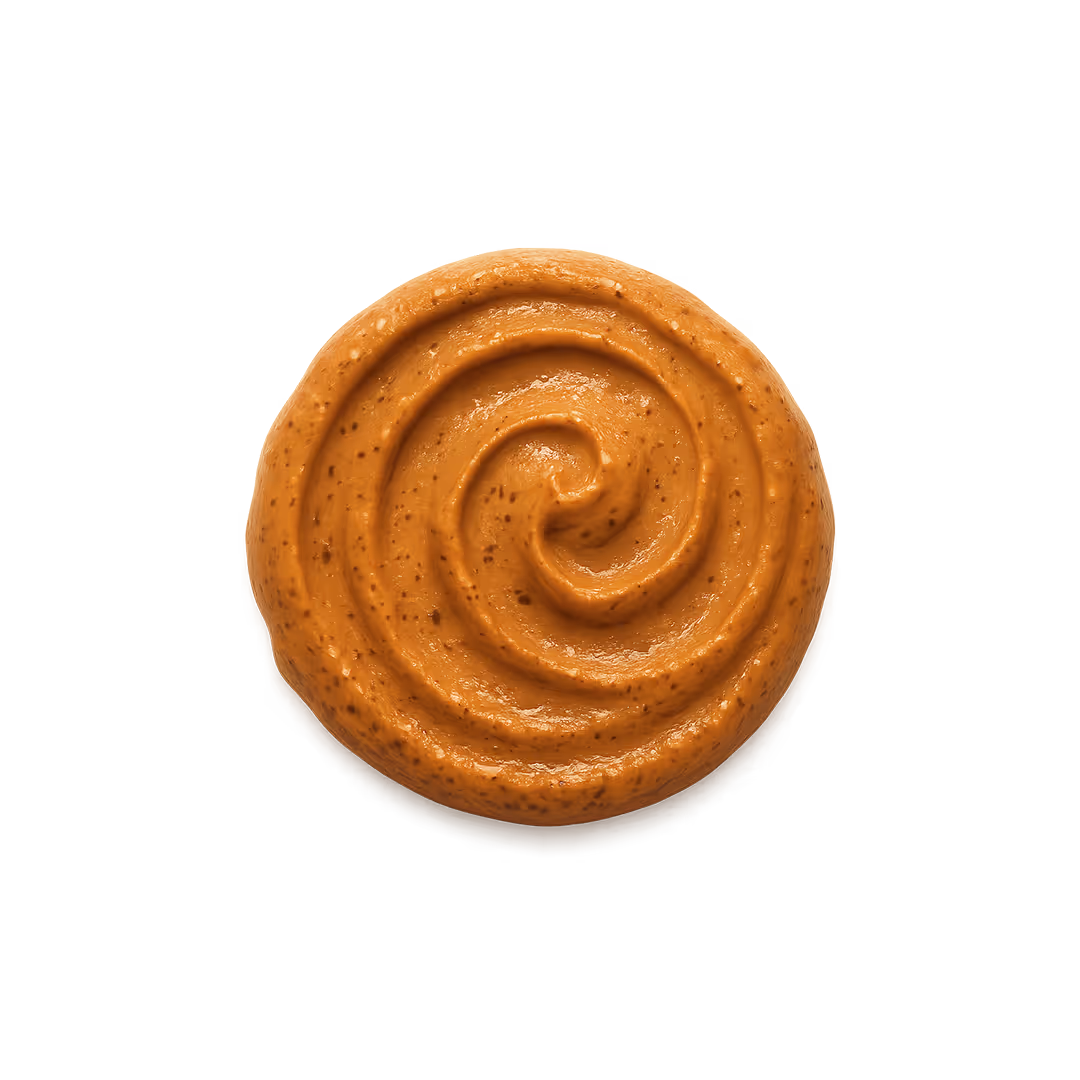 Close-up of a swirl of creamy, brown chipotle sauce with visible spices on a gradient background.