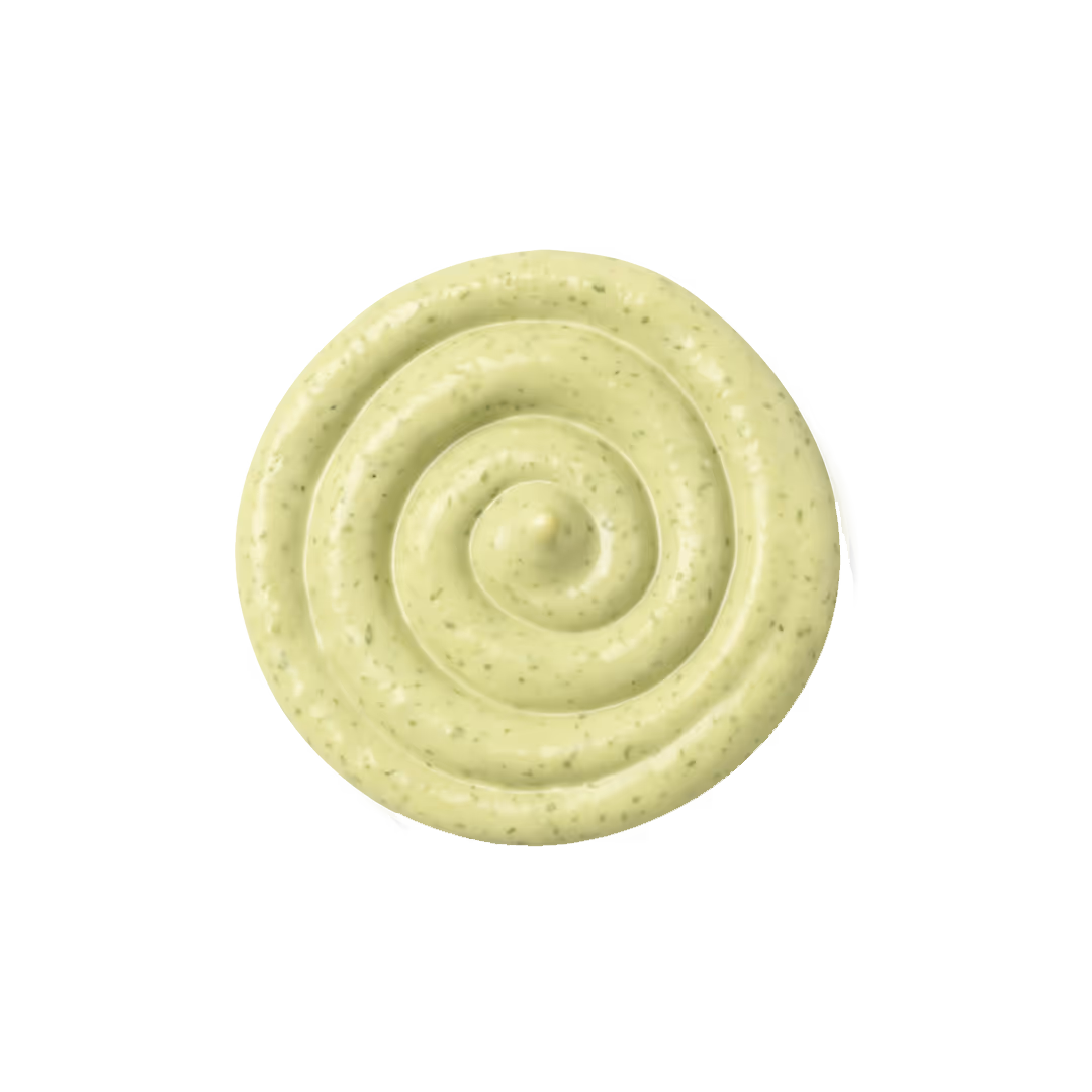 Spiral of creamy cilantro lime sauce with visible herb specks on a white background.