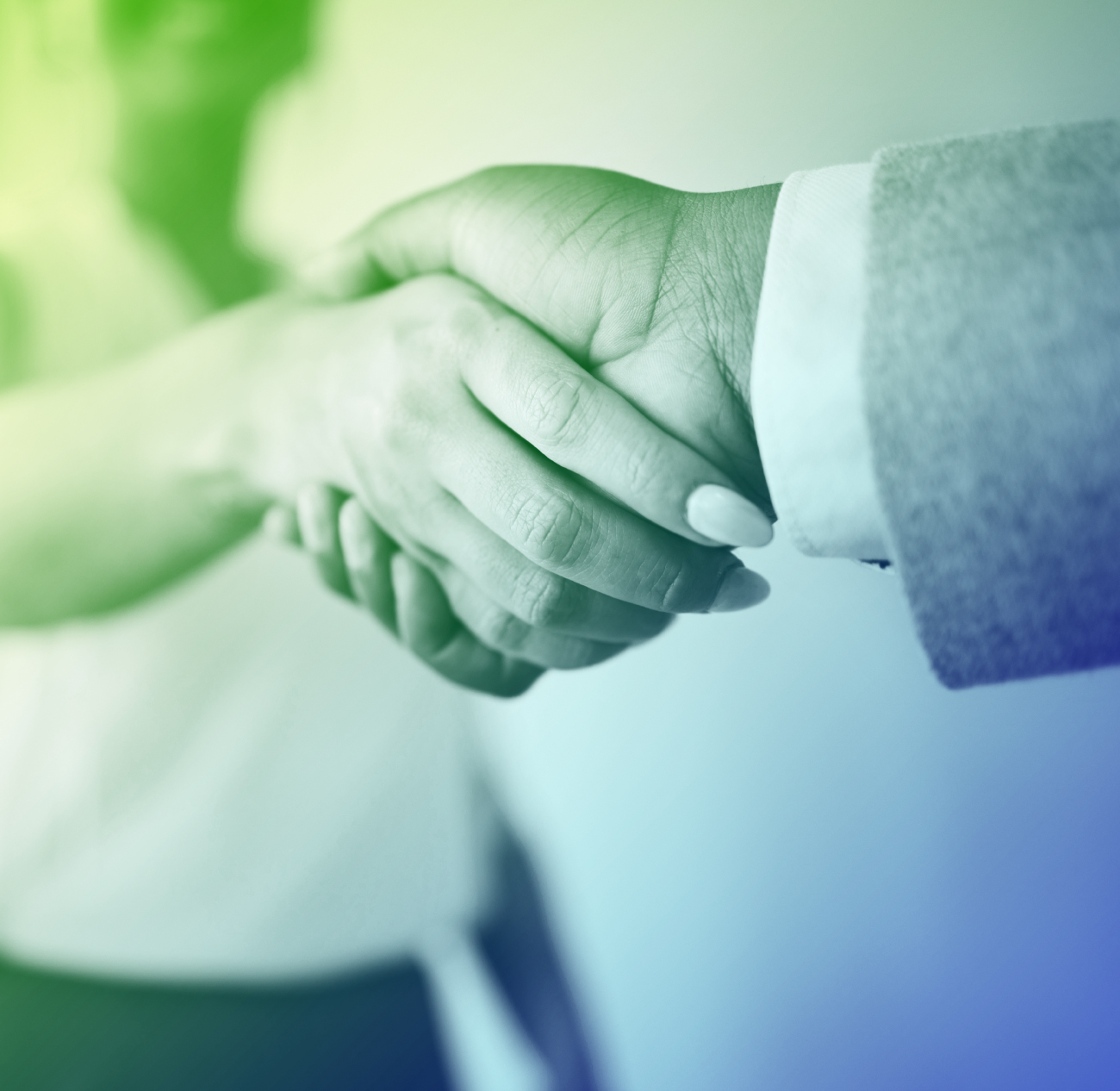 Two people shaking hands in a close-up shot, one wearing a suit jacket.