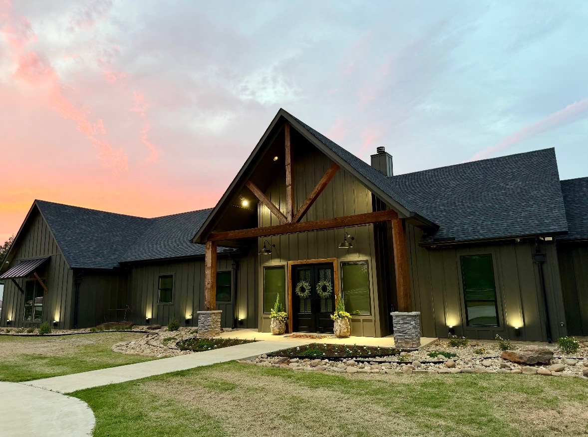 East Texas custom home with landscape planting, stone beds, walkway and low-voltage lighting by Saddle Rock Land Co.