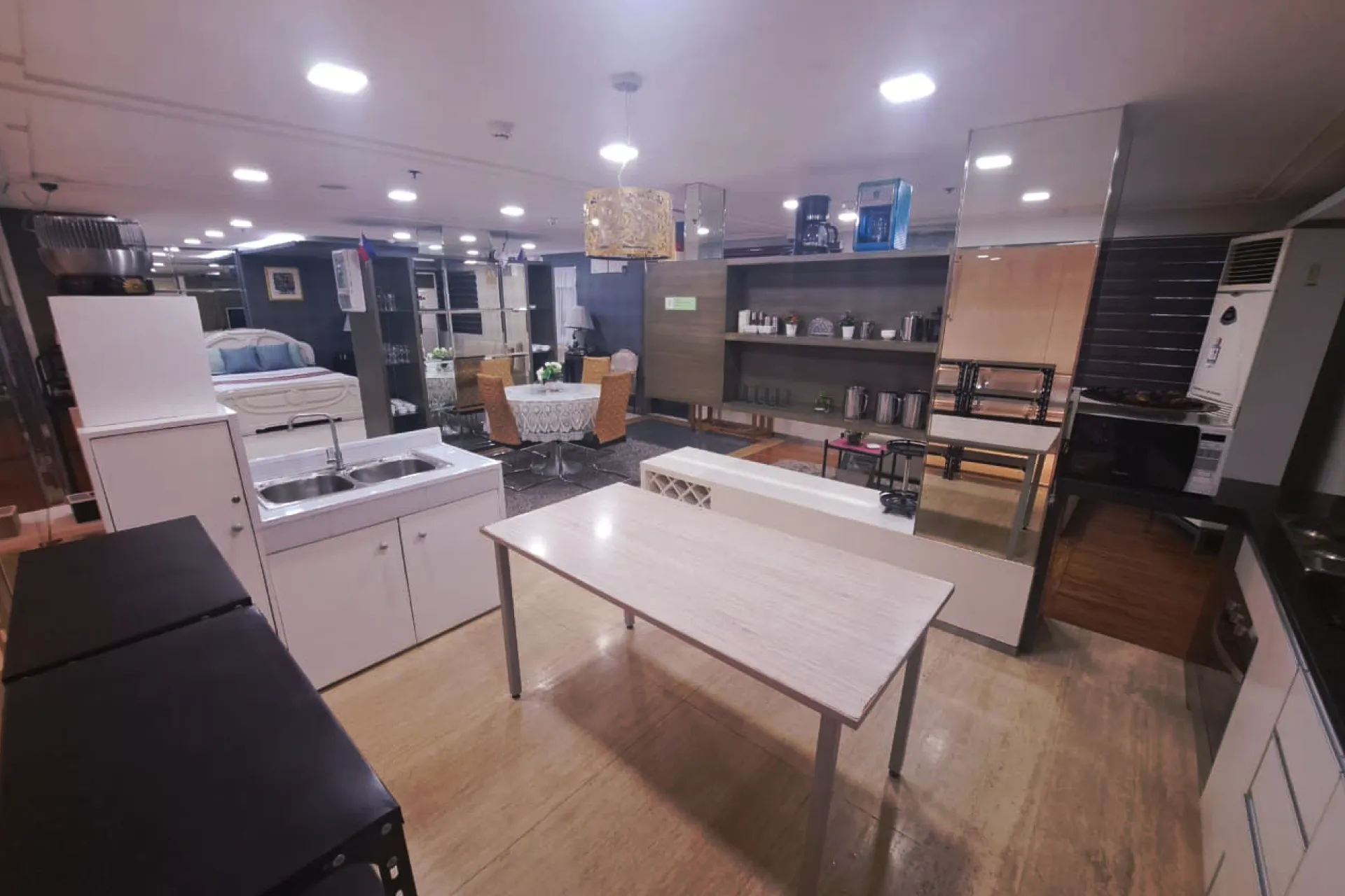 A comprehensive housekeeping training lab designed like a studio apartment, featuring a bedroom, kitchenette, and dining set.
