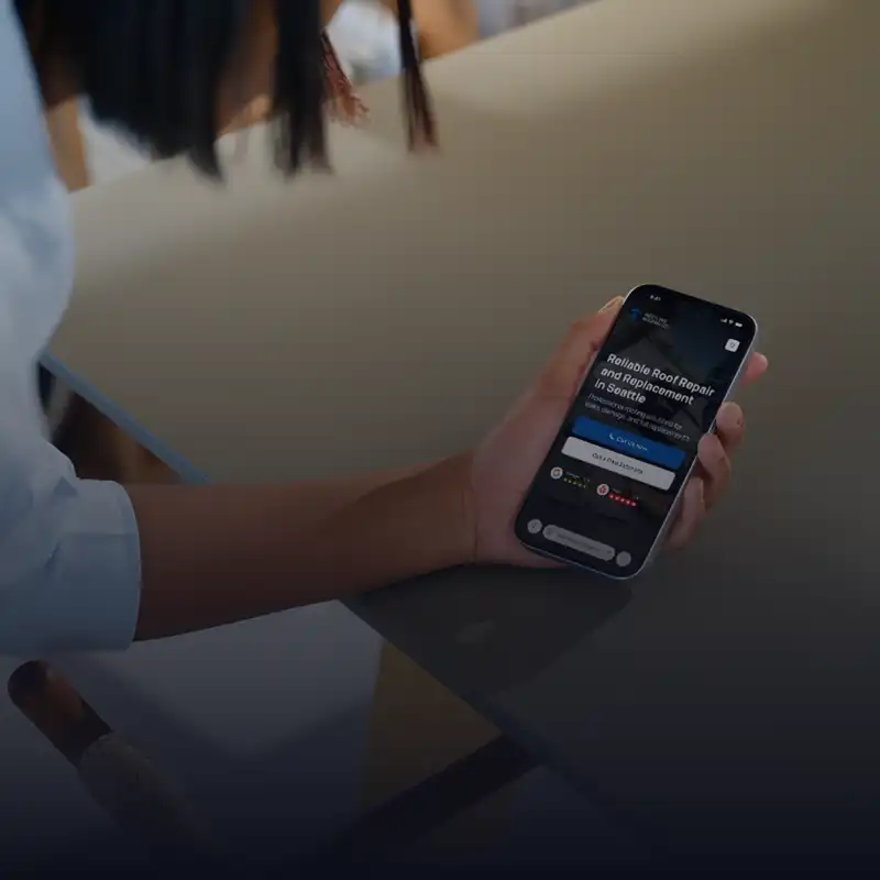 Person holding smartphone displaying a roofing service app showing reliable roof repair and replacement in Seattle.