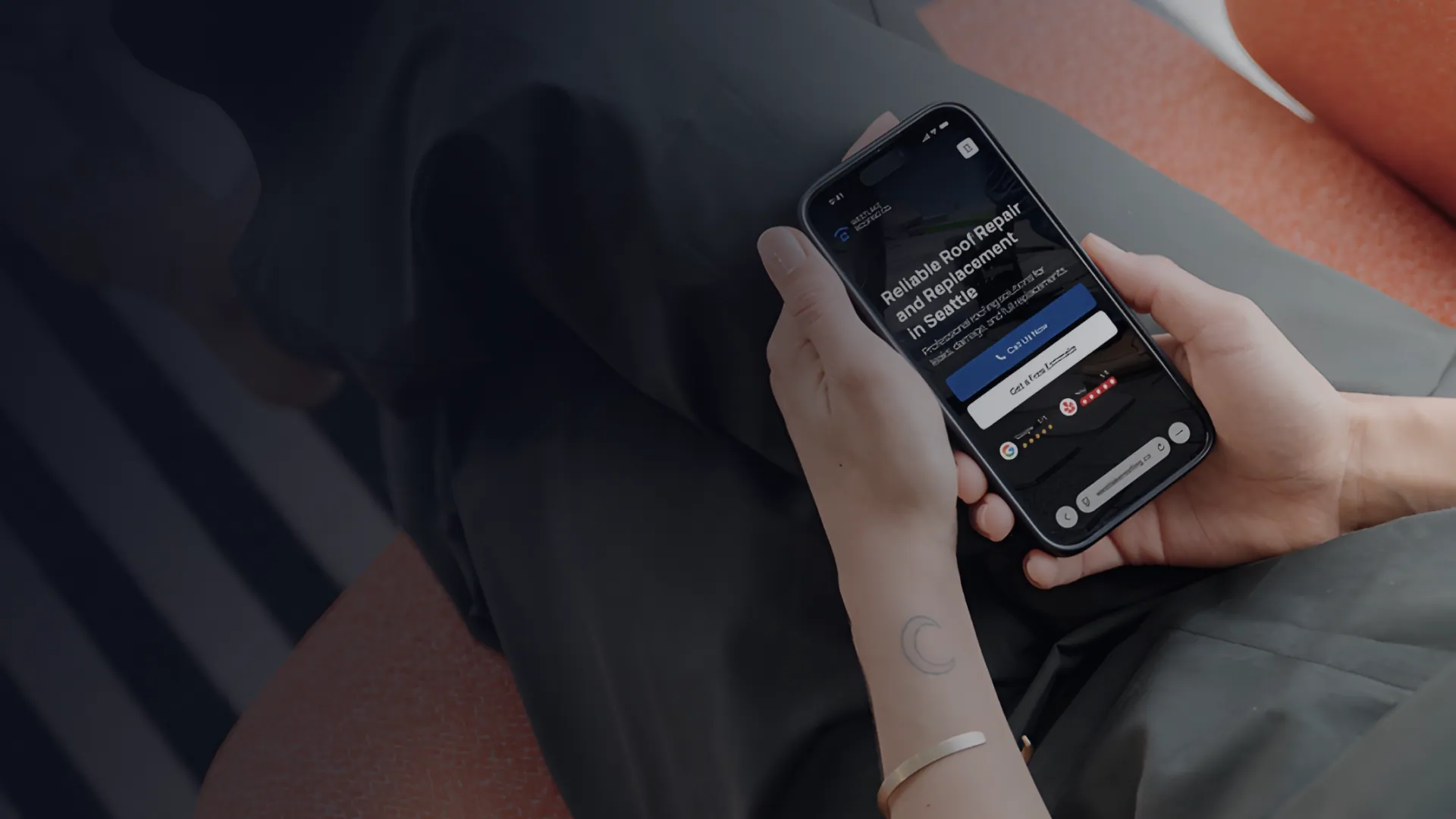 Person holding a smartphone displaying a website for reliable roof repair and replacement services in Seattle.