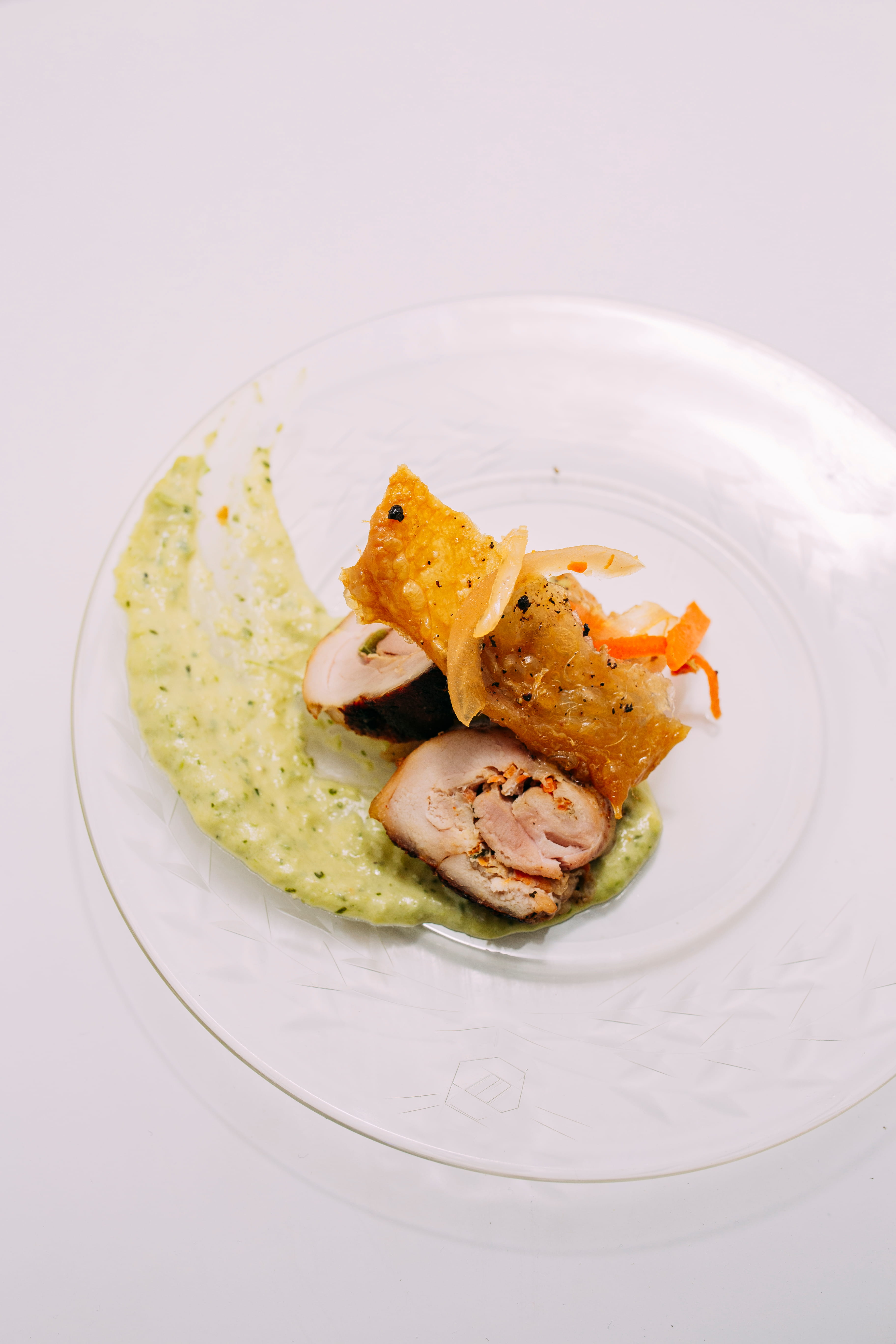 Chicken cutlet rolled with pikliz, epis, a chimmicurri béchamel topped with a slice of fried chicken skin