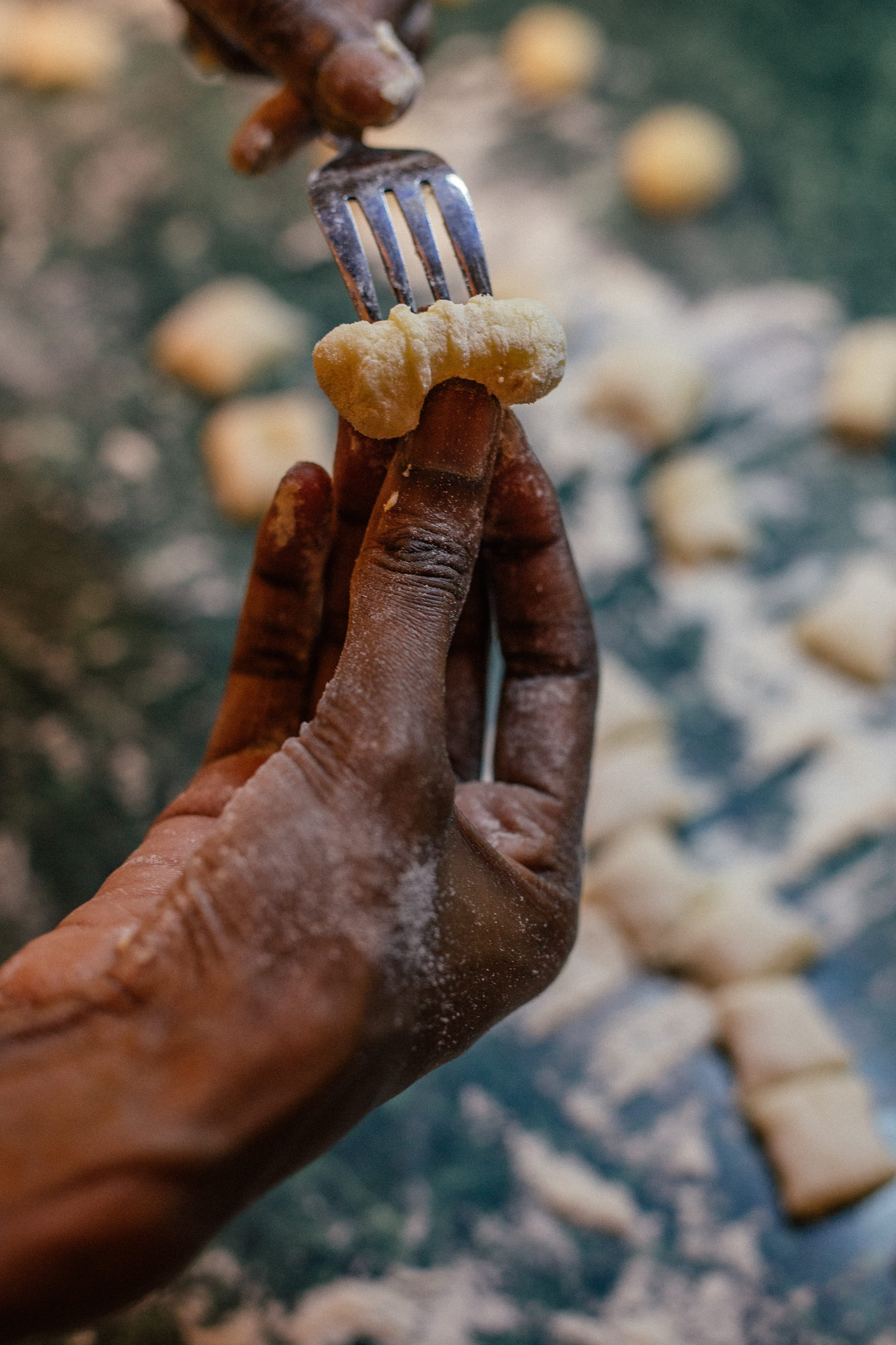 Chef's hand holding and forking Potato Pasta