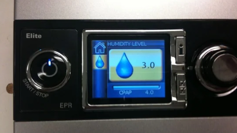 Close-up of a CPAP machine display showing humidity level at 3.0 and CPAP pressure at 4.0, with start/stop button on the left.