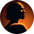 Silhouette of a woman with curly hair against an orange glowing background.