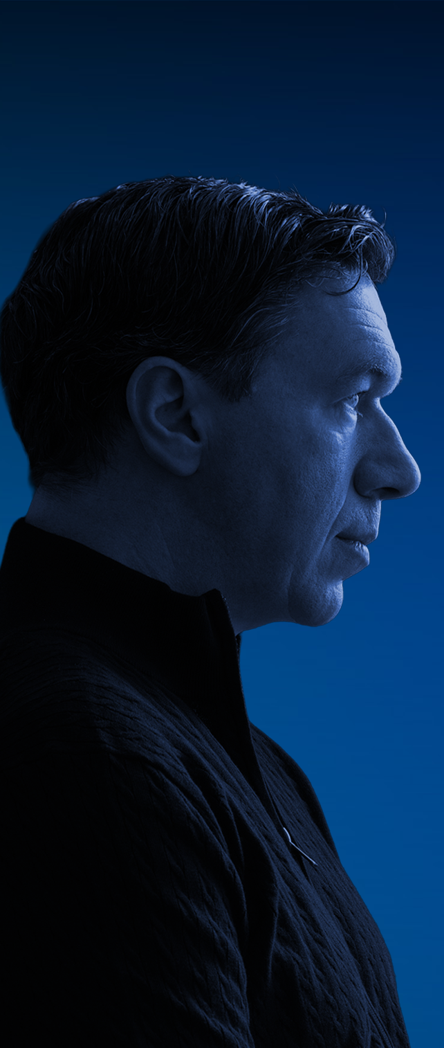 Profile image of Topher Field, Australian political commentator and filmmaker, looking forward against a blue backdrop.