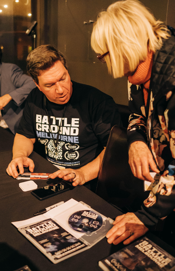 Topher Field engages with a supporter while signing a book at a public event, discussing political ideas.