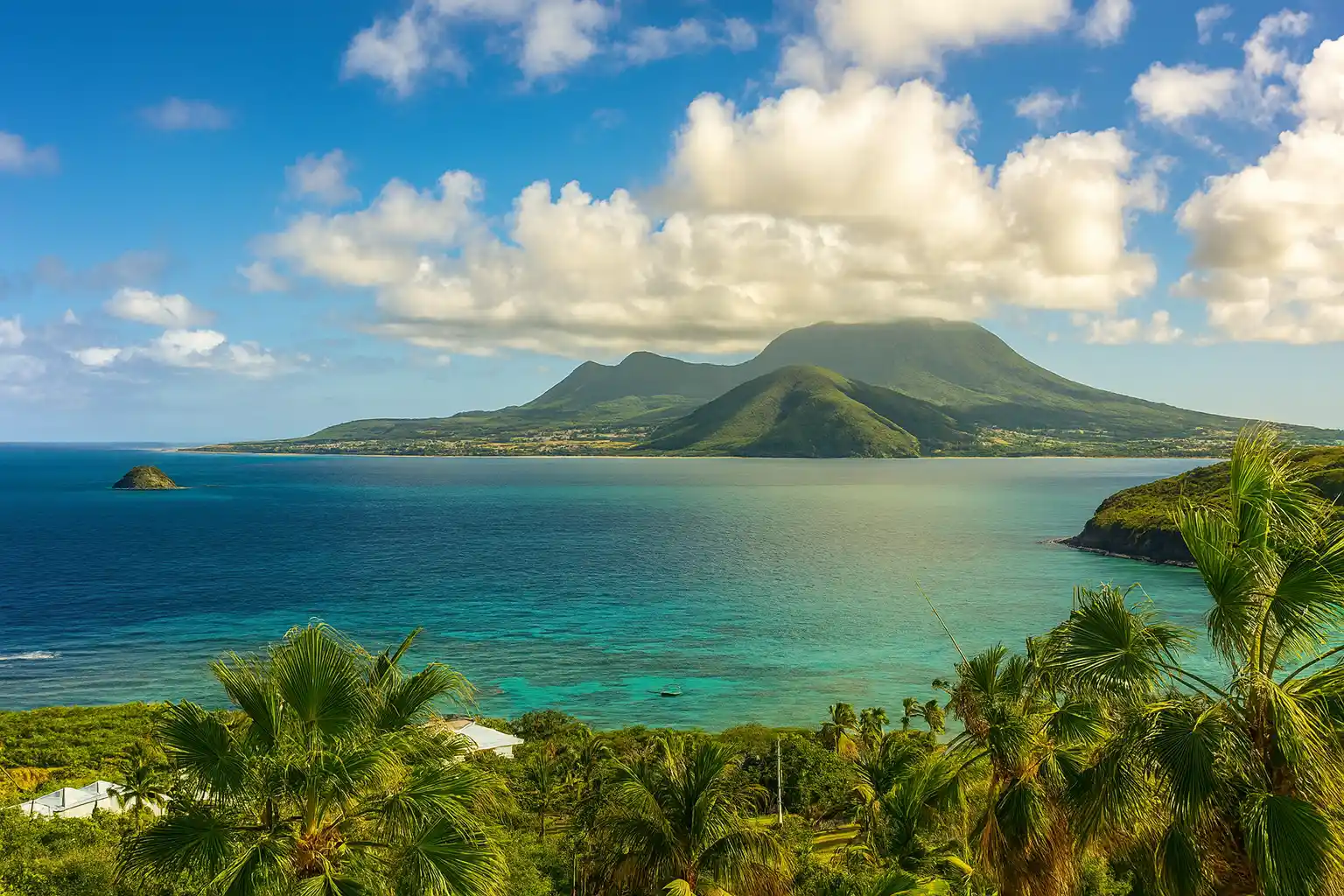  Scenic view of the ocean and mountains from a hilltop, showcasing the natural beauty of the landscape.