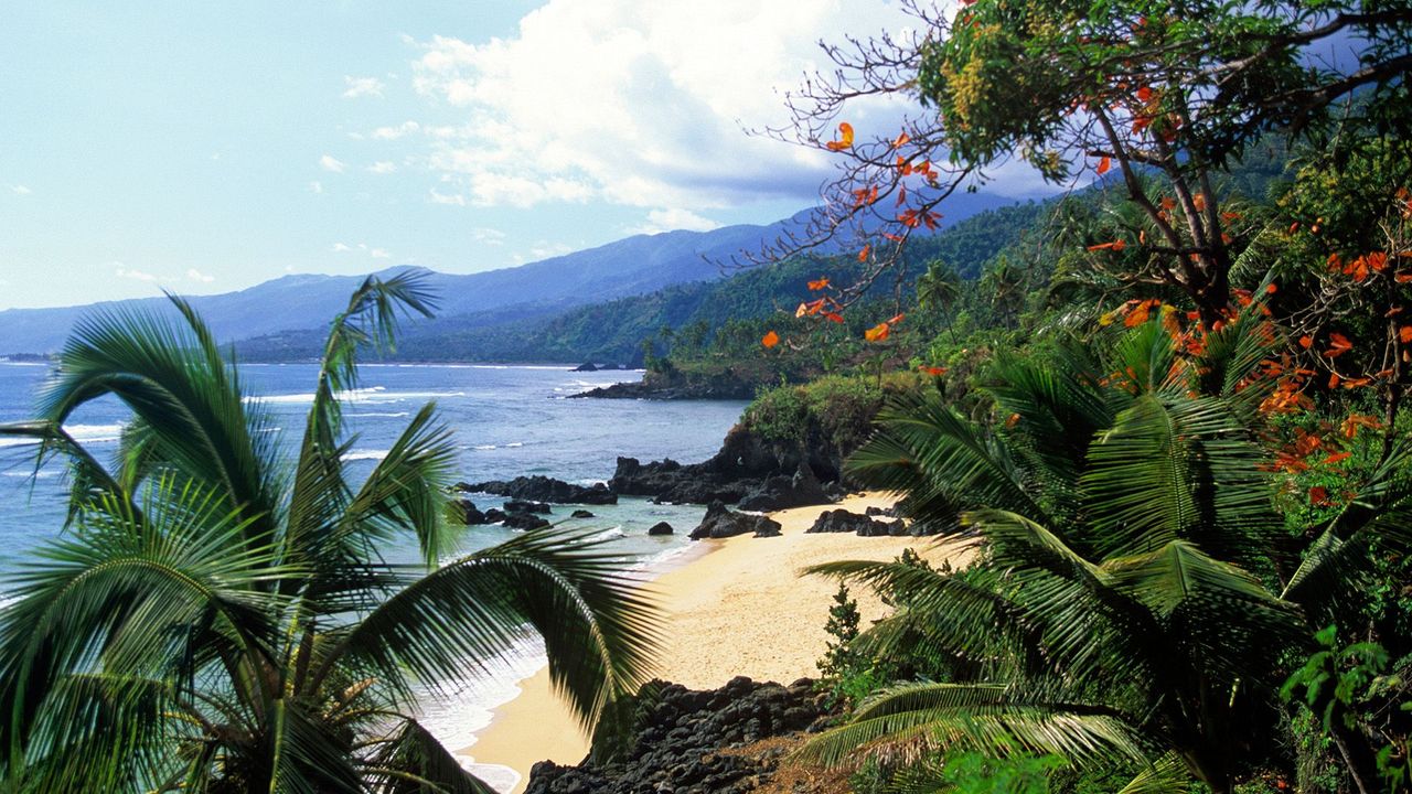  Scenic view of the ocean and mountains from a hilltop, showcasing the natural beauty of the landscape.