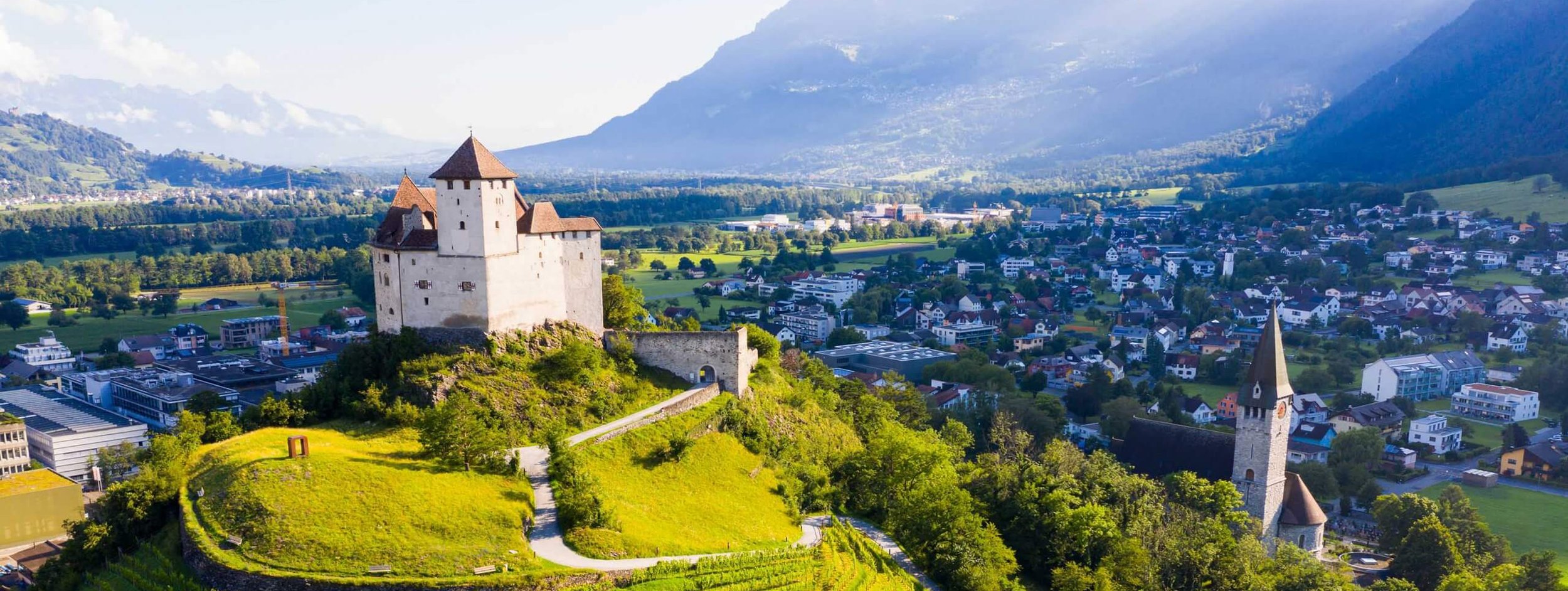  Scenic view of the ocean and mountains from a hilltop, showcasing the natural beauty of the landscape.