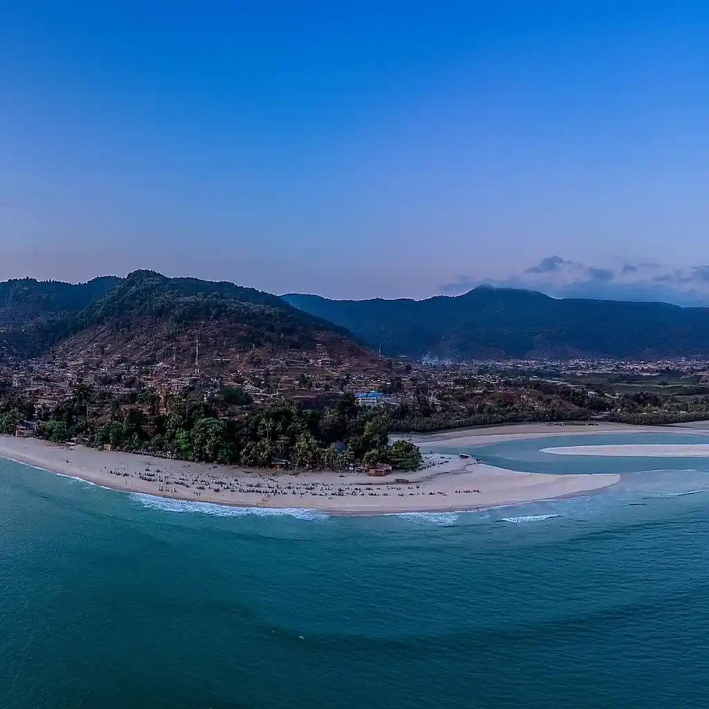  Scenic view of the ocean and mountains from a hilltop, showcasing the natural beauty of the landscape.