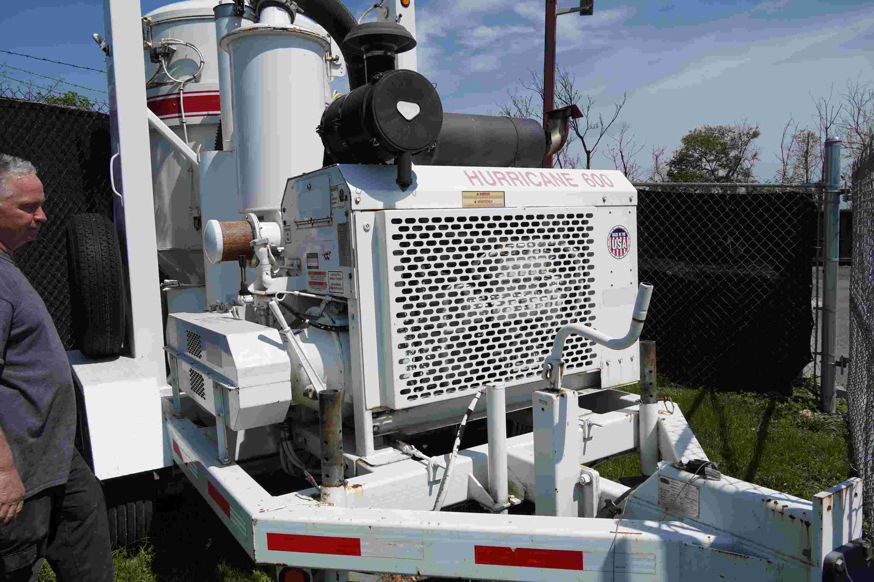 Image of a man standing next to a large machine.