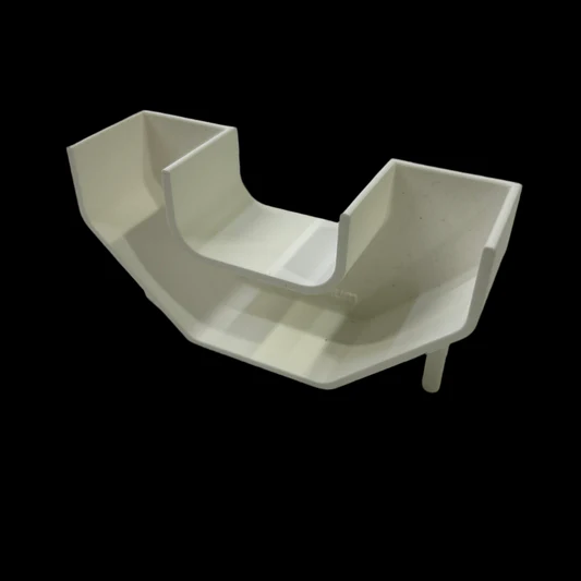 White, angled plastic chair seat with raised sides and back against a black background.