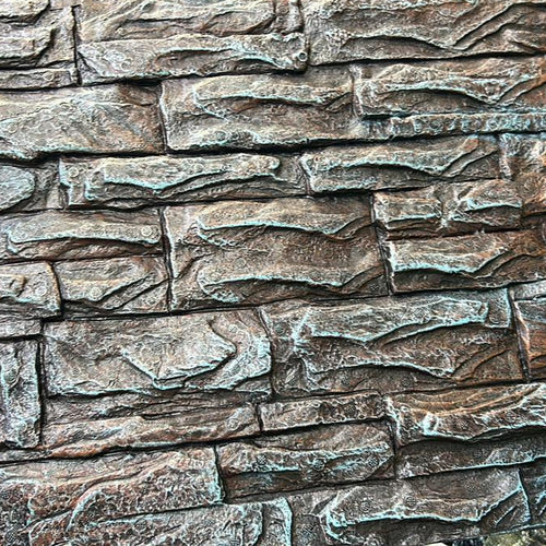 Close-up of a textured stone wall with irregular rectangular stones in earthy brown and gray tones.