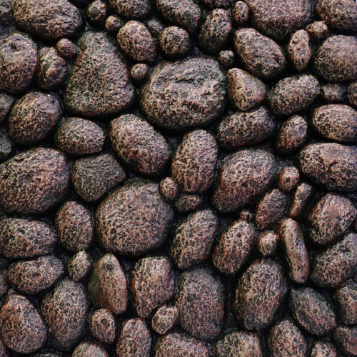 Close-up of dark textured pebbles tightly packed together with a rough, speckled surface.