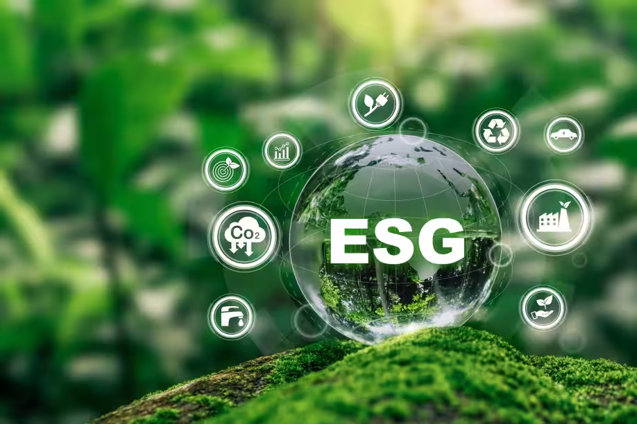Transparent globe with ESG text surrounded by icons of environmental and sustainability concepts on green moss background.