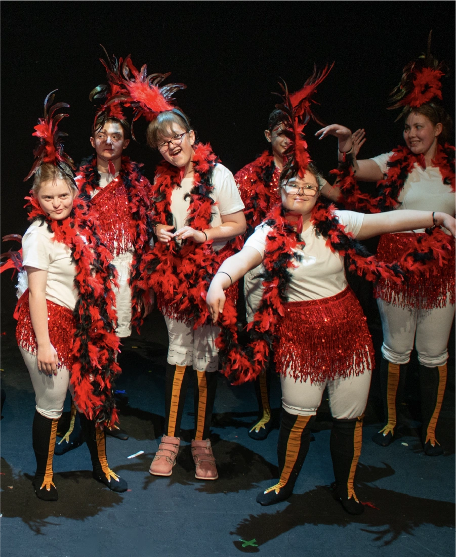 Woman wearing a grey hijab sorting black clothing in a clear plastic bin indoors.