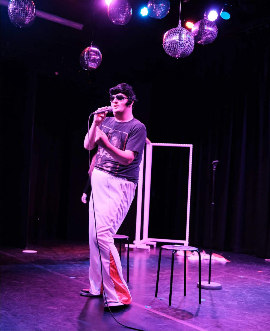 Woman wearing a grey hijab sorting black clothing in a clear plastic bin indoors.