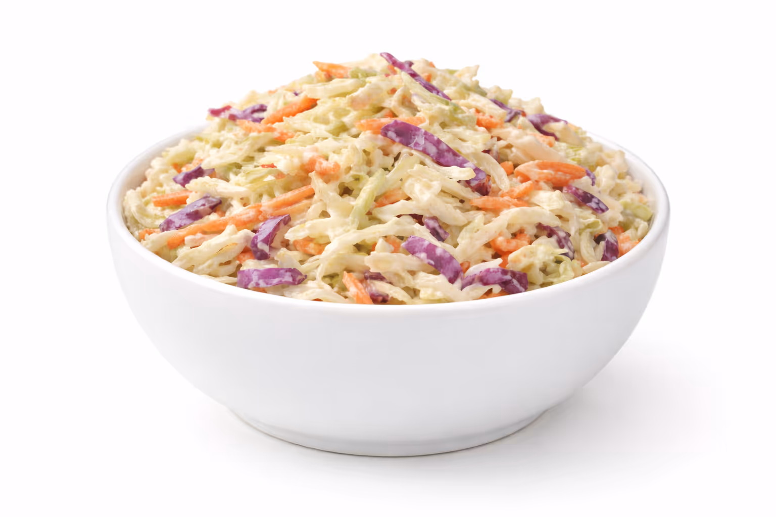 White bowl filled with coleslaw made of shredded cabbage, carrots, and purple cabbage in creamy dressing.