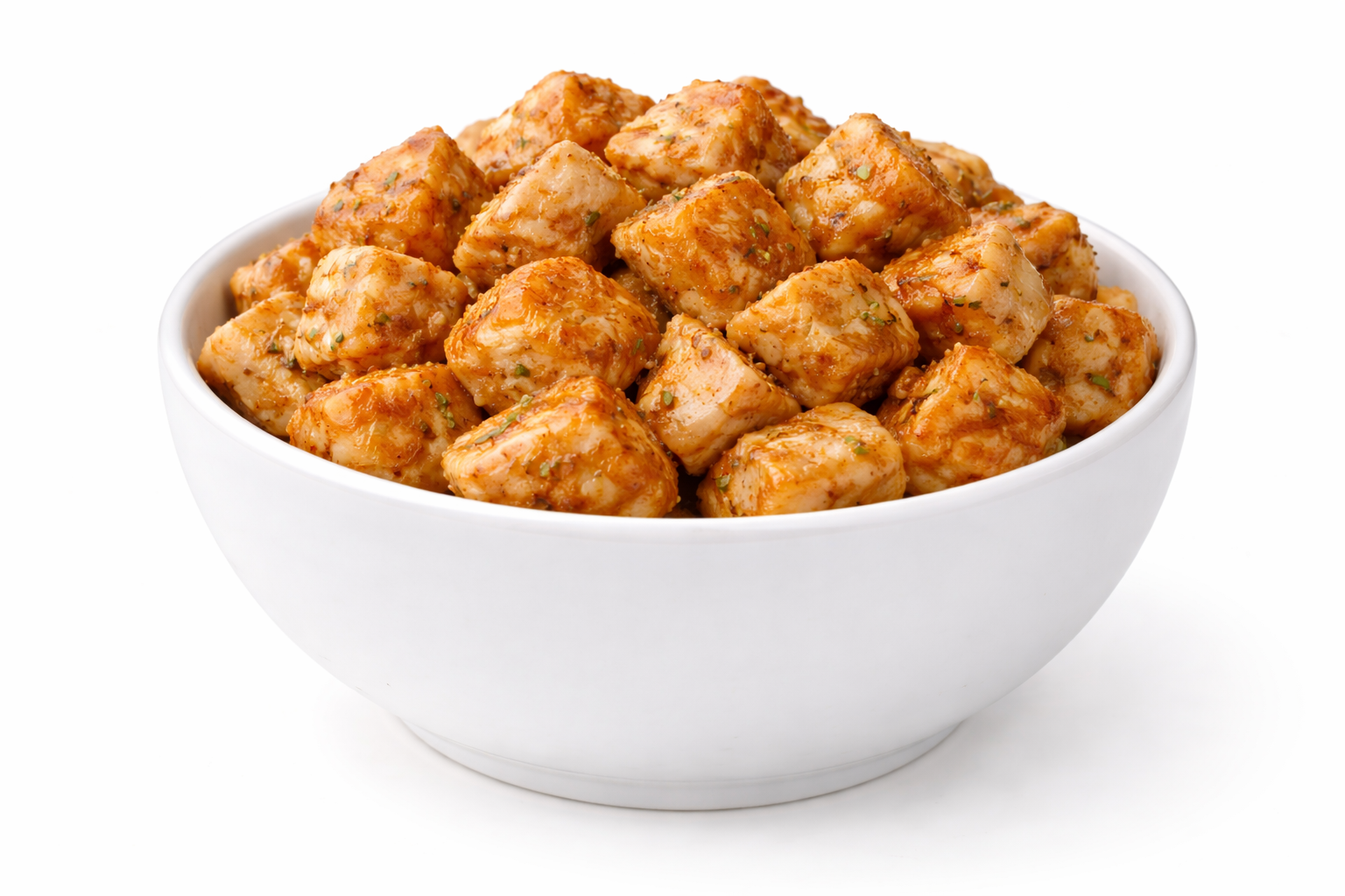 White bowl filled with seasoned, cooked chicken breast cubes.