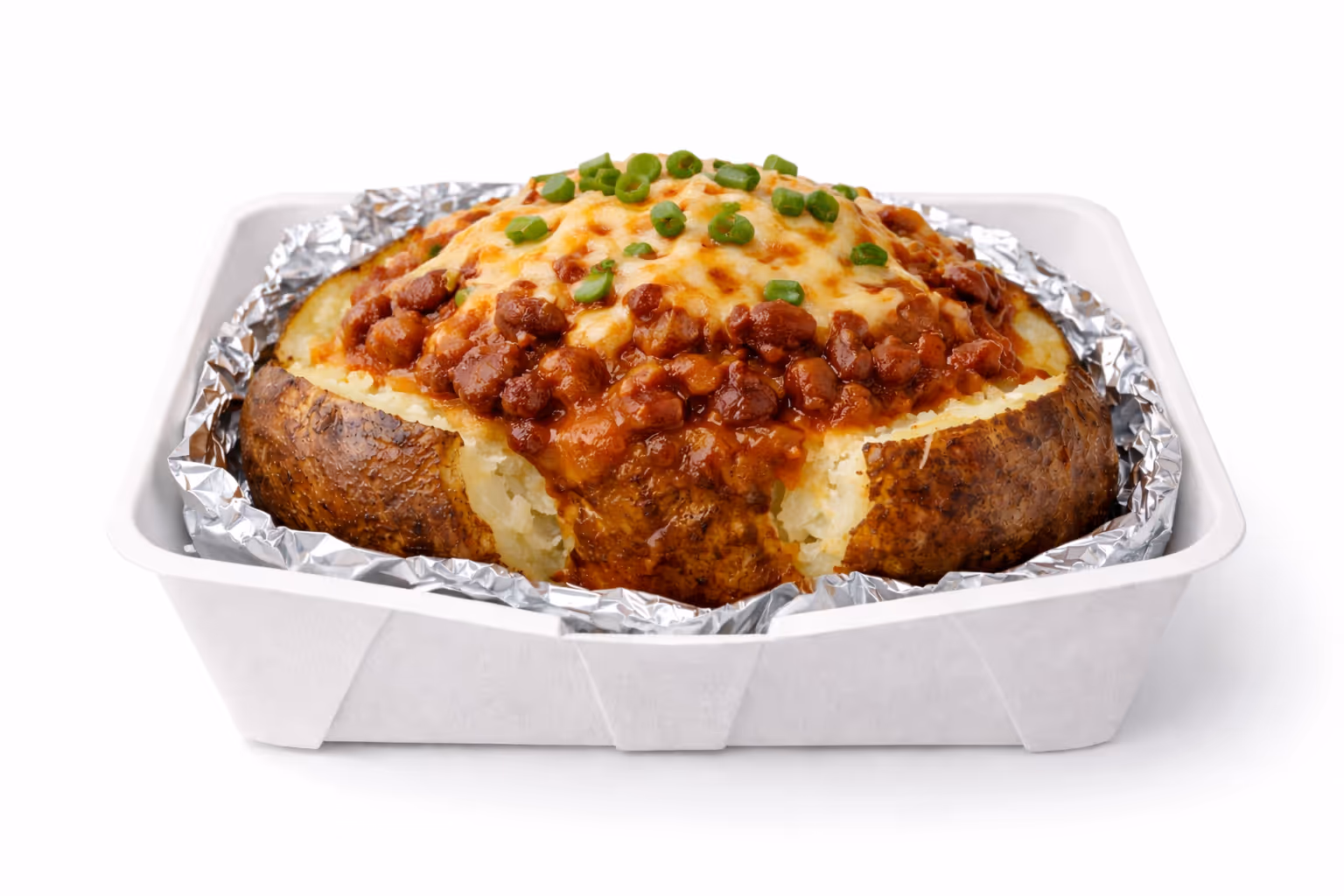 Baked potato topped with chili beans, melted cheese, and chopped green onions in a foil-lined container.