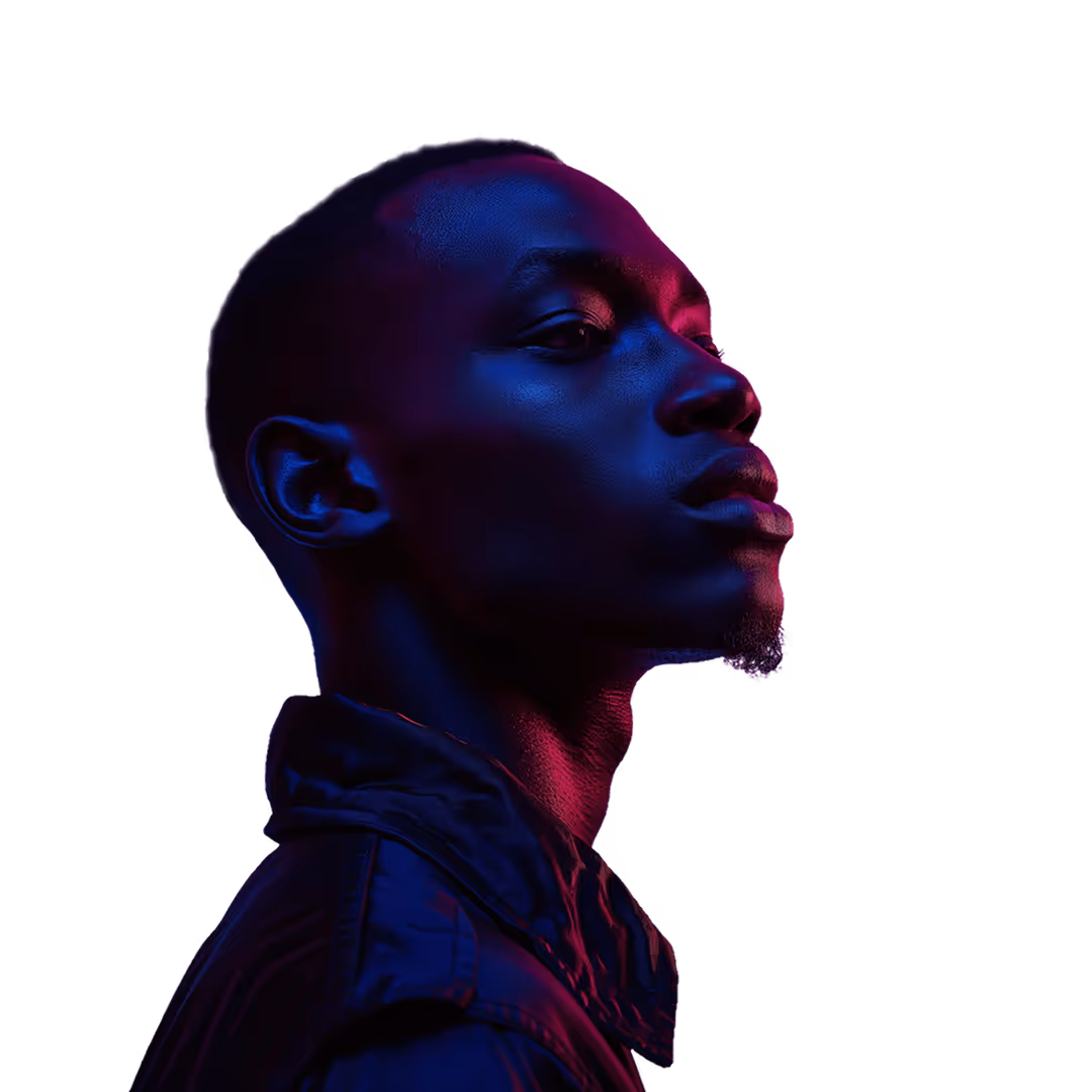 Side profile of a man with short hair lit by blue and pink lighting against a black background.