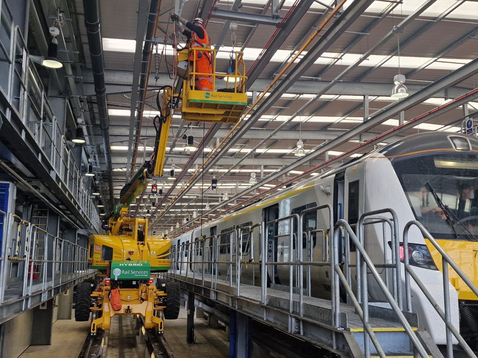 Aerial view of multiple large industrial generators with exhaust pipes arranged in a fenced facility surrounded by greenery.