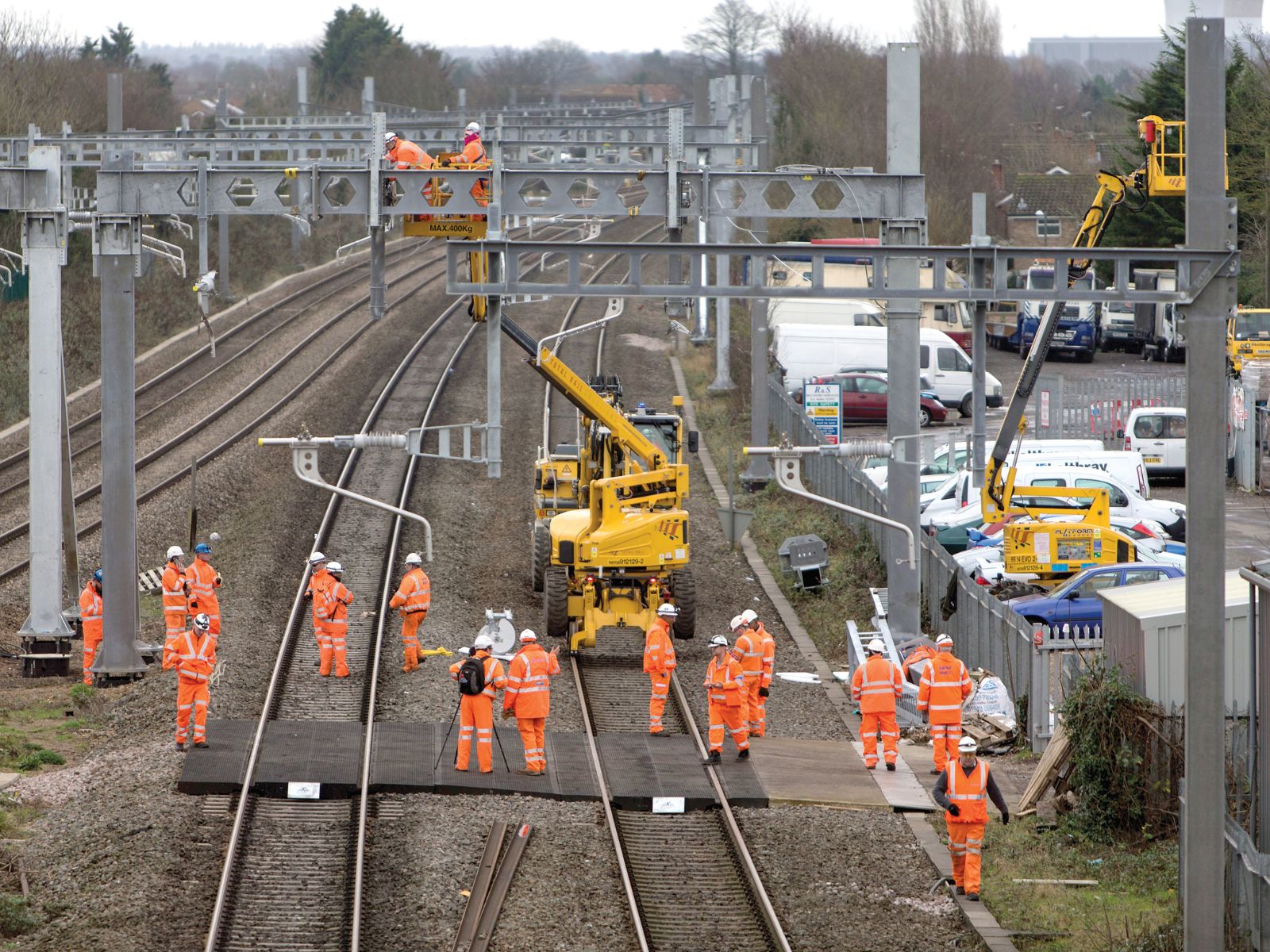Yellow modern tracked boom lift with an extended articulated arm and a metal work platform.